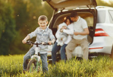 family in a summer forest by the open trunk