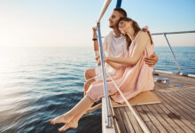 happy beautiful adult couple sitting on side of yacht watching at seaside and hugging while on vacation tan might fade but such memories you share with one you love last forever